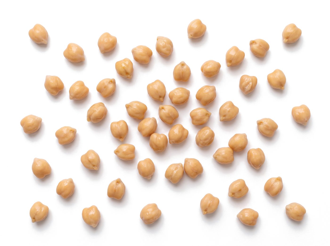 Cooked garbanzo beans scattered across a white surface